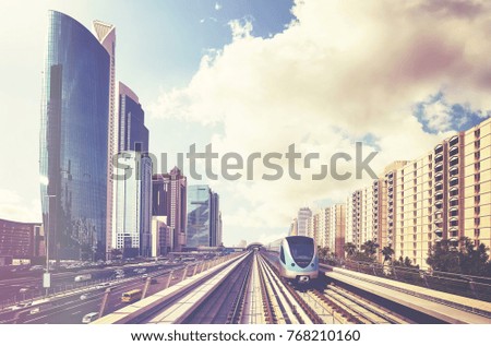 Metro train in Dubai downtown, retro stylized picture, United Arab Emirates.