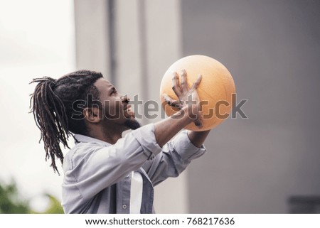 african american man throwing basketball ball at street