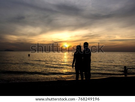 silhouette image of the lover with the sea and sky in the sunset as background