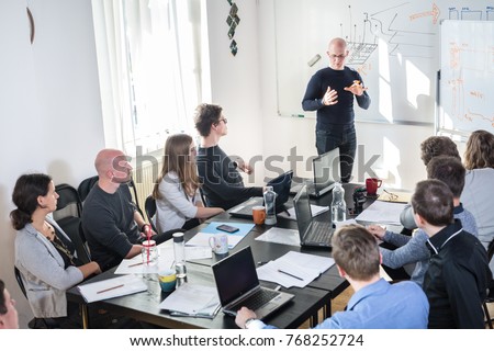 Relaxed informal IT business startup company meeting. Team leader discussing and brainstorming new approaches and ideas with colleagues. Startup business and entrepreneurship concept. Royalty-Free Stock Photo #768252724