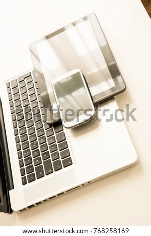 A smartphone, a laptop computer and a Tablet PC together on a desktop.