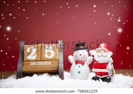 Santa Claus and Snow man Doll  with Wooden calendar set on the 25 of december  on red background, chrismas concept