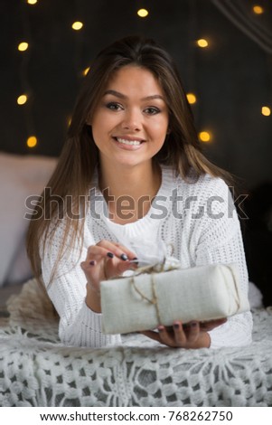 Young beauty woman with Christmas gift box, new year tree background