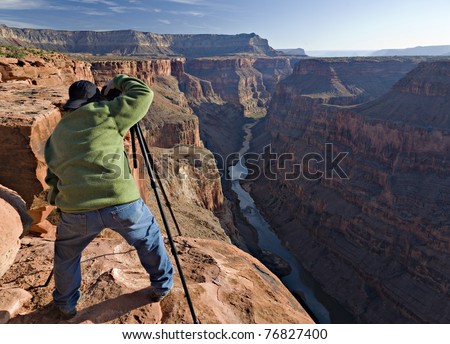 A Photographer taking a picture at Toroweap Point in the Grand Canyon Royalty-Free Stock Photo #76827400