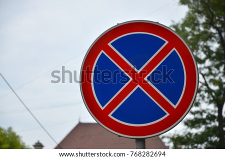 Round road sign with a red cross on a blue background. A sign means a parking prohibition