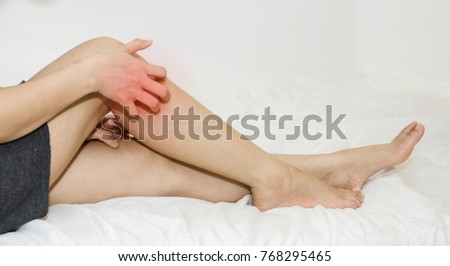 Asian girl scratches her leg.