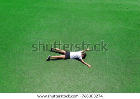 girl lying on a green football field