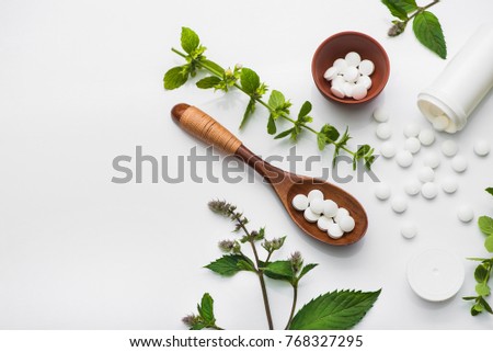 Organic medical pills with herbal plant on white background. ethnoscience concept. top view Royalty-Free Stock Photo #768327295