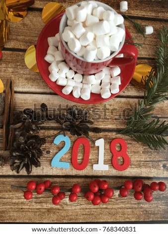 red cup with marshmallows. 2018 wooden date with Christmas decorations.