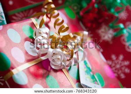 close up of white and gold curly ribbon on a beautifully wrapped christmas present with burring