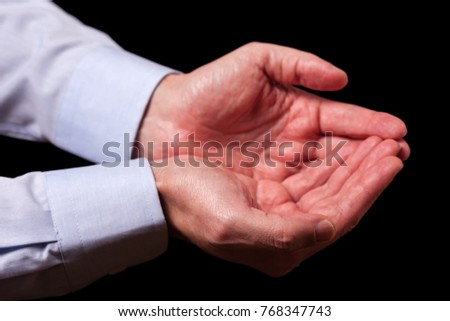 Mature male businessman hands together with empty palms up. Concept for man praying, prayer, faith, religion, religious, worship or giving, offering, begging, receiving. Black background.