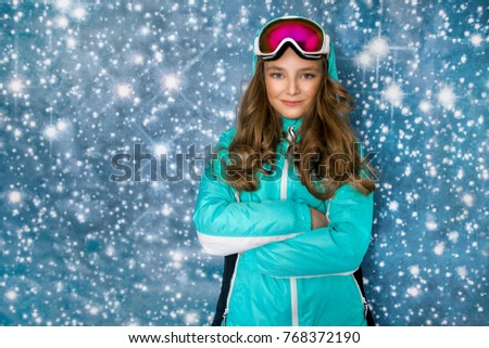 Cute, beautiful blonde young girl dressed in ski outfit and ski goggles