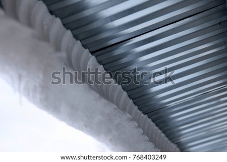 a large amount of snow hangs from the roof