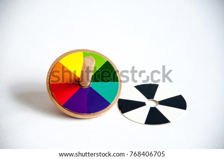 isolated on white wooden and colored whirligig. Childrens toy - colorful spinning, close-up.