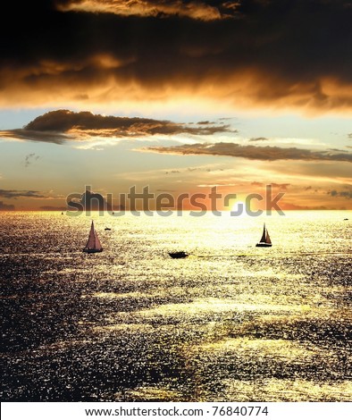 Sunset over the sea with sailing boats