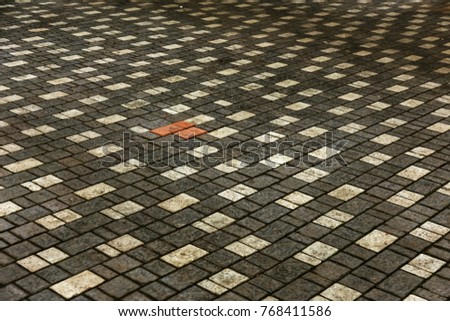 beautiful background laid paving slabs on pedestrian path. Monotonous pattern of multicolored glazed paving slabs. Photo site with paving slabs with small defects and cracks coming out in perspective