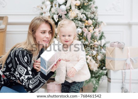 Christmas or New year celebration. Happy mom gives daughter gift decorated with ribbon