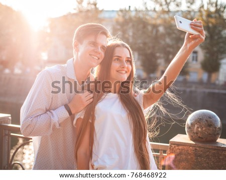 Beautiful couple taking selfie near the river