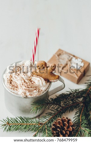 Winter hot drink with gingerbread men cookie and christmas decoration on the wooden white table. Selective focus