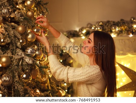 
 Closeup woman decorating a Christmas tree New Year's toys at home 