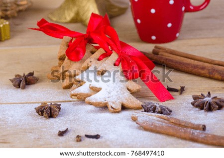 Gingerbread and christmas cookies and spices on wooden background with white sugar