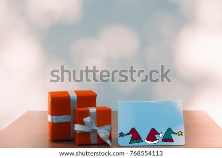 Christmas, new year, presents box and postcard mockup on wooden table over bokeh wall background and copy text space for writing messages