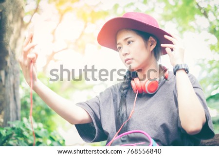 Copy space area for advertising content.Filter effect and sun flare.Selected focus on female's hand holding modern telephone while making photo. Blurred background of young woman