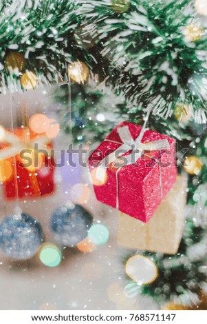 Christmas gifts closeup with Red and golden and blue gifts with illuminated garland with natural light. New Year baubles closeup photo with bokeh. Winter holiday light decoration.