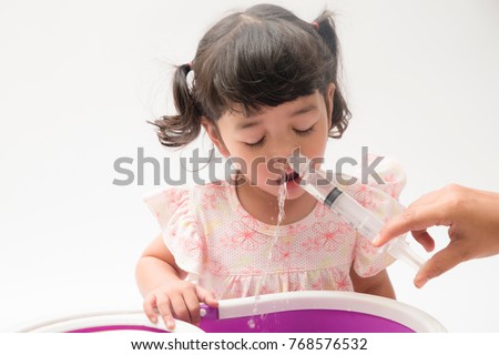 Asian mother making nasal wash for her baby girl by flushing kid'nose with syringe and saline. An Irrigation can benefit people who have sinus problems,nasal allergies isolated on white background Royalty-Free Stock Photo #768576532