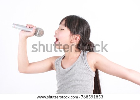 Pretty little asian girl with the microphone in her hand isolated on white background, Music song and education concept
