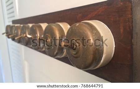 Antique light control switch system made of brass on wooden frame.  (Home interiors vintage Concept) Royalty-Free Stock Photo #768644791