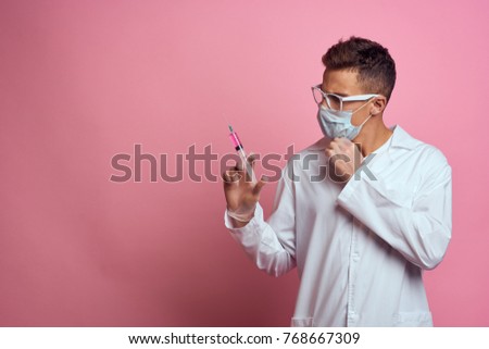  laboratory worker with a syringe on a pink background                              