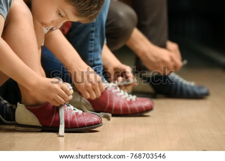 Family changing shoes in bowling club