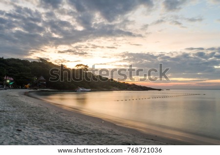 Sunset on the sea and beach under the cloudy sky.