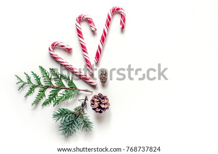 New Year's unusual composition with spruce branches, sweets and cones. Christmas background for presentation of work or text. Beautiful greeting card. View from above. Copy space