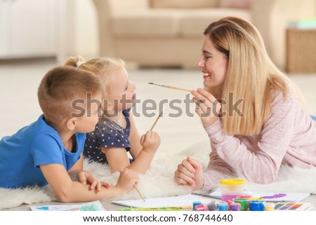 Mother with cute children painting, indoors