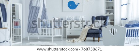 Picture of a whale hanging over a chest of drawers in a newborn room interior