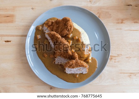 Omelette Rice with Japanese Curry and Breaded Deep Fried Pork Cutlet on Modern Wood Table