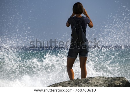 woman taking pictures of Sea Storm and tempest on the coast
