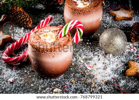Traditional Christmas drinks. North Pole Cocktail with candy cane sweets, peppermint, hot chocolate or cocoa, ginger ad milk. Dark background, with Christmas decoration, copy space