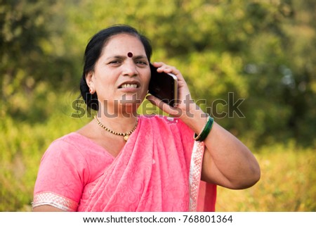 Portrait of an Indian woman in traditional clothing talking on smartphone.