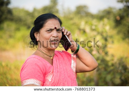 Portrait of an Indian woman in traditional clothing talking on smartphone.