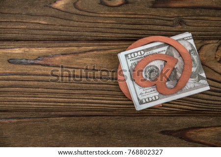 Concept, e-mail symbol, money one hundred dollar bills in place against a tree texture background. idea: money transfer, earnings on the Internet, wallet.