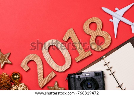 Travel concept on wooden table.Christmas decorations,camera, map and wooden numbers 2018