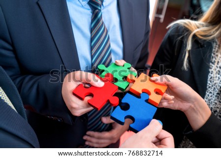 Group of business people puting togeher a puzzle. Strategy concept
