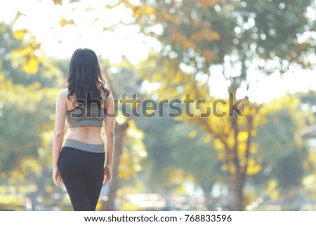 Woman runner warming up before running at park nature background