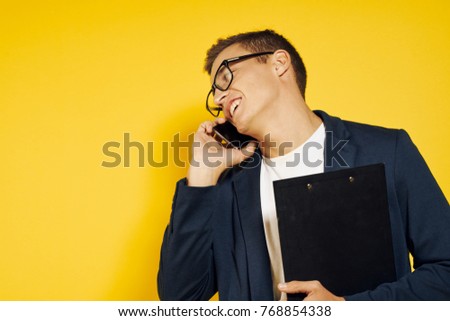 business man talking on the phone on a yellow background                               