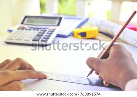 A young Asian  Architect drawing on architectural project business, architecture, building, construction and people concept - close up of architect hands with compass measuring living house blueprint