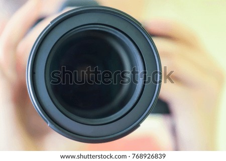 Photographer holding a camera, toned, closeup.