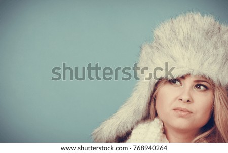 Accessories and clothes for cold days, fashion concept. Blonde woman in winter warm furry hat in russian style and scarf.